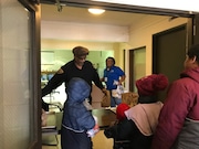 Michael Maclin, a security officer with the Cleveland school district. hands out lunches to students at Marion Sterling elementary school Friday in the Central neighborhood.