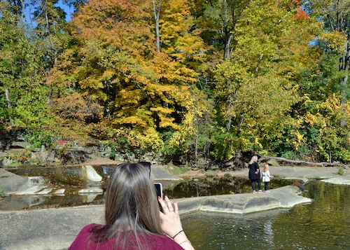 woman taking photo of others and fall colors.