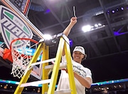 Akron Zips forward Enrique Freeman swings his net clipping after defeating the Kent State Golden Flashes to win the MAC Men's Basketball Championship finals. 