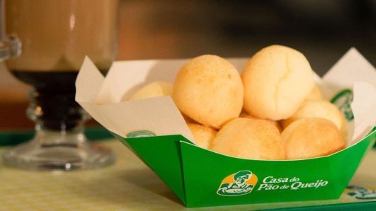 Pães de queijo em cesta com logo da Casa do Pão de Queijo