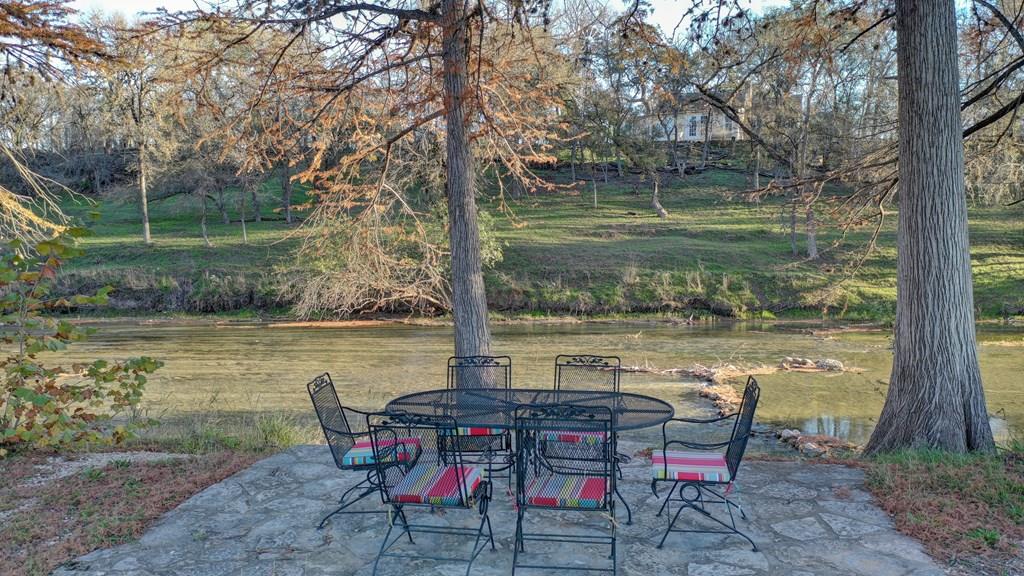 a view of a lake with table and chairs