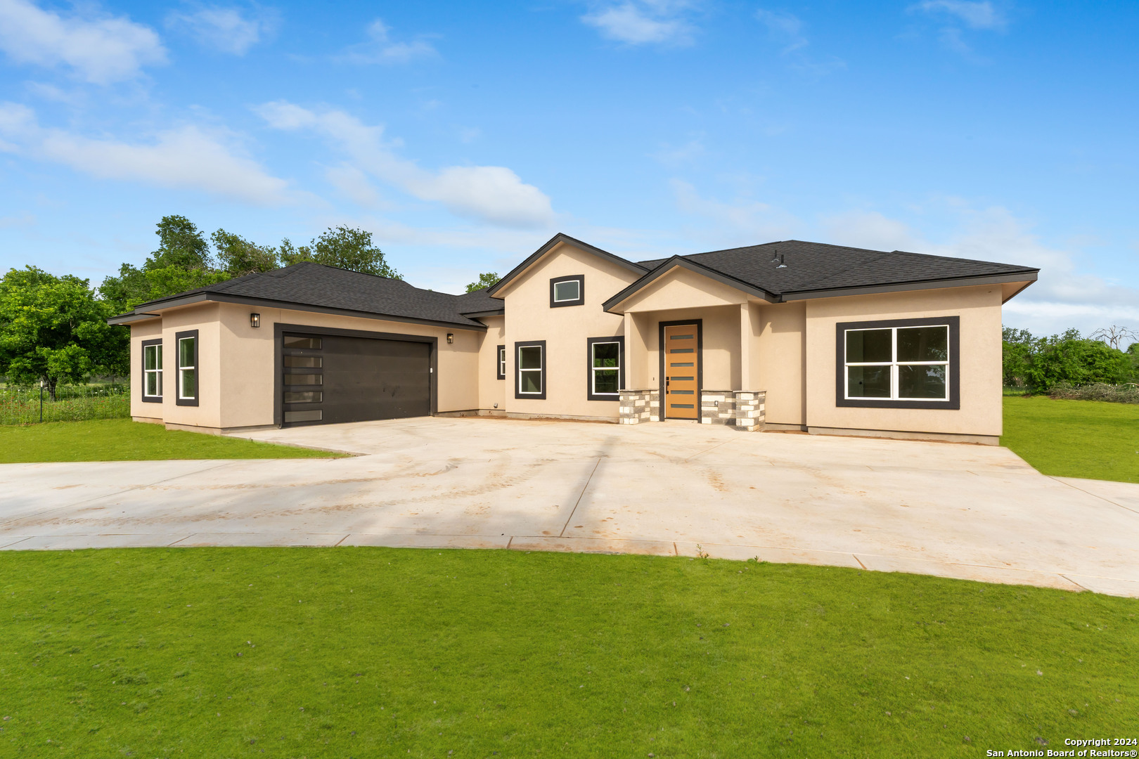 a front view of a house with a garden and yard