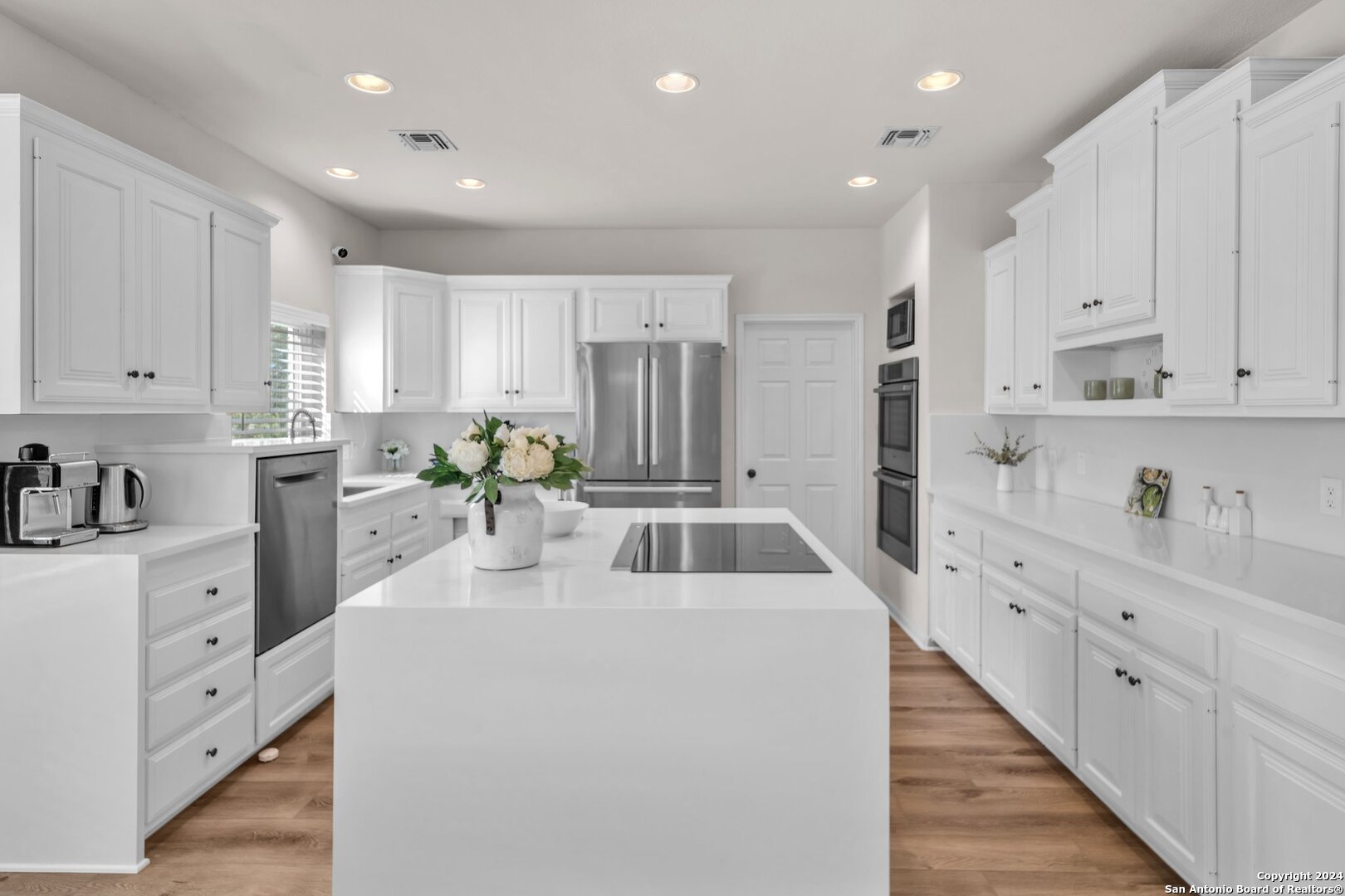 a kitchen with white cabinets sink and white appliances