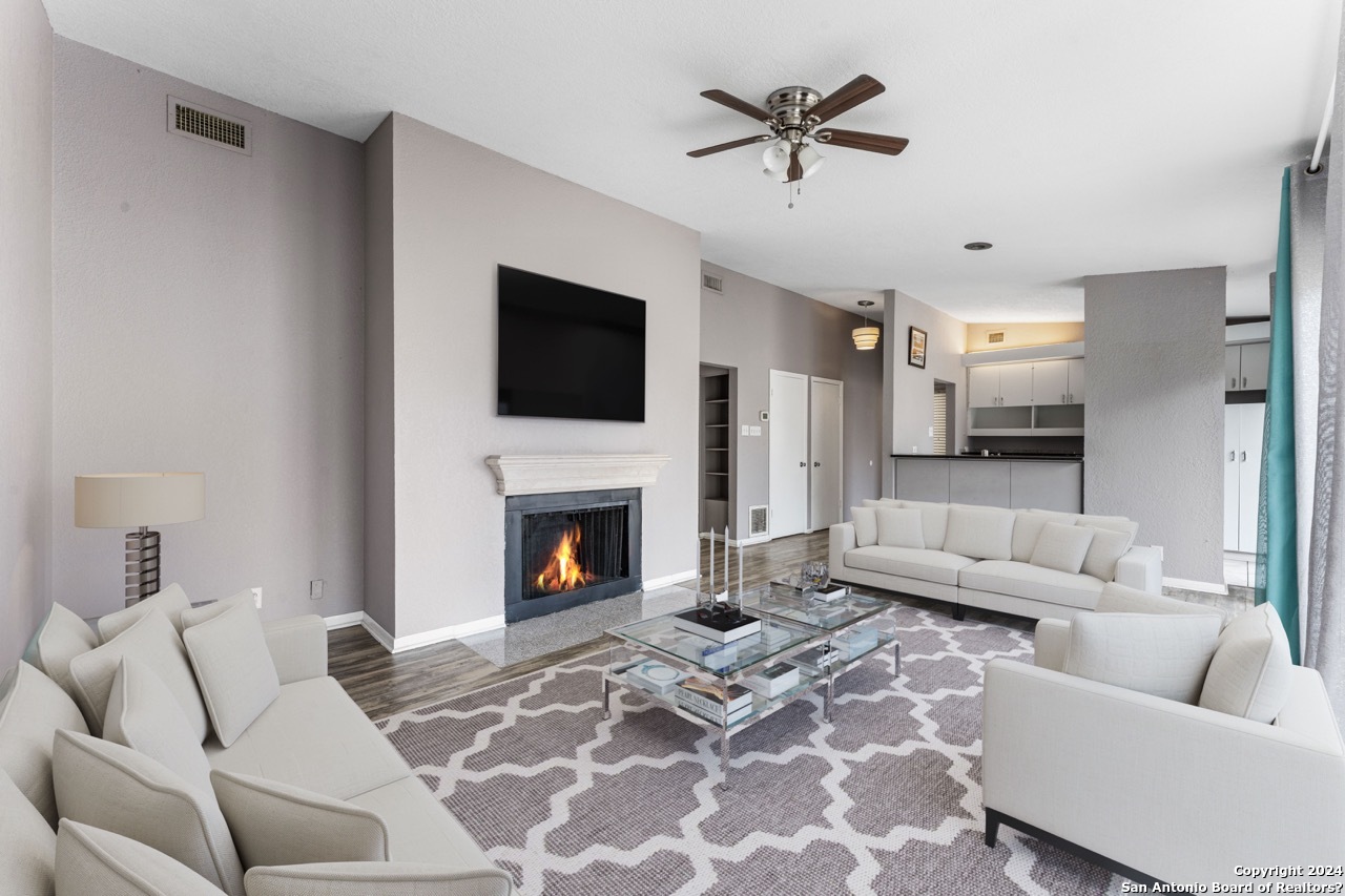 a living room with furniture a flat screen tv and a fireplace