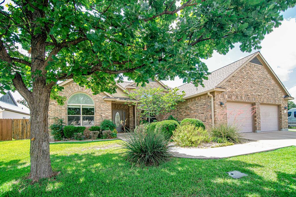 a view of a house with a yard and potted plants large tree