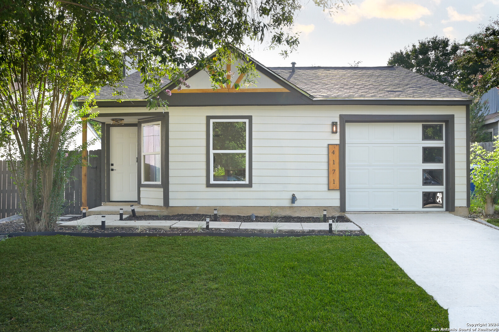 a front view of a house with a garden and yard