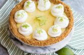 A key lime pie on a striped table linen.