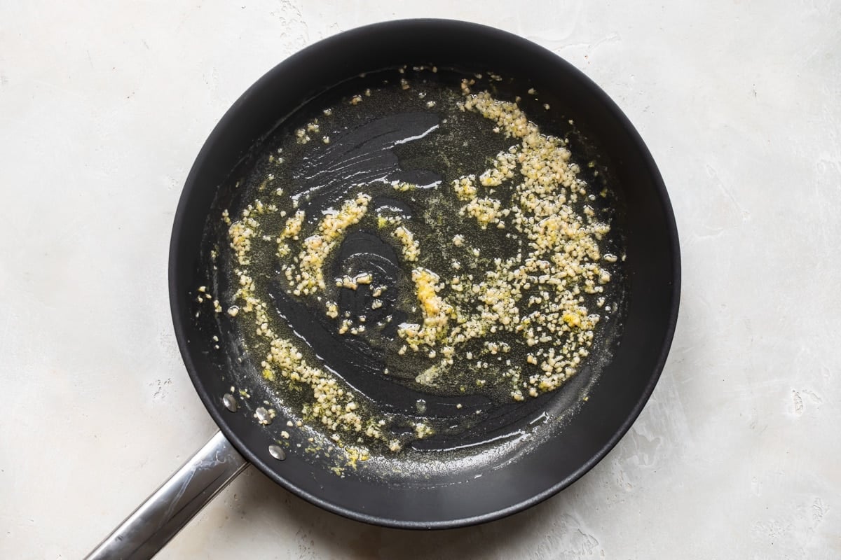 Garlic browning in a black skillet.