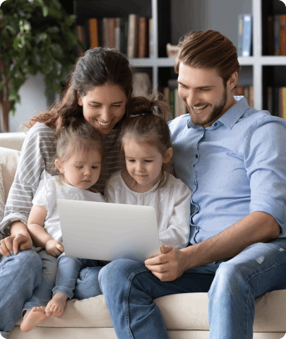 Couple with 2 kids sitting on the couch.