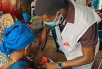 MSF doctor checking child's heart beat inside measles isolation unit at Um Sangour Refugees Camp, White Nile State.