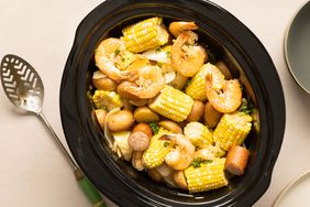 A slow-cooker filled with the cooked ingredients for the easy slow-cooker shrimp boil recipe