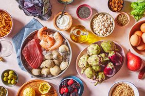 a group of Mediterranean Diet foods that include steak, shrimp, berries, artichokes, yogurt, seeds, pasta, nuts, eggs, and olive oil