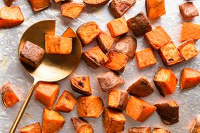 Overhead view of a metal baking sheet with cubed and roasted sweet potatoes from Roasted Sweet Potatoes recipe