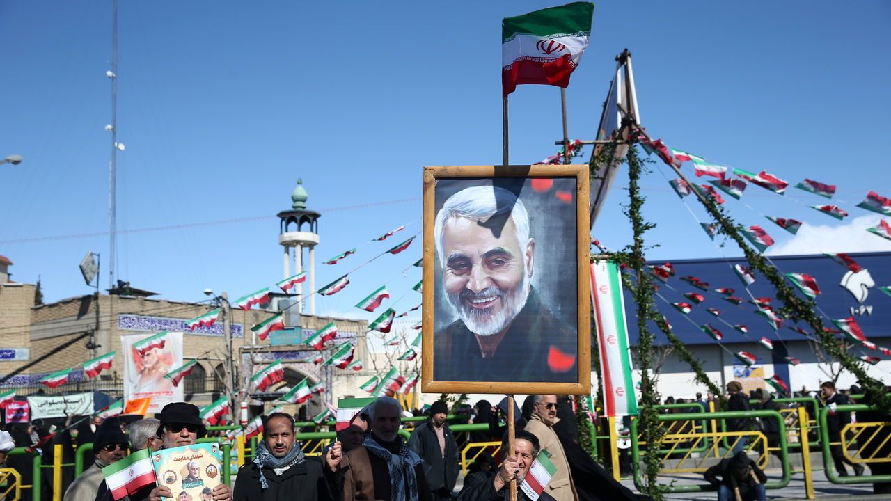 An Iranian man holds a picture of the late Iran's Quds Force top commander Qassem Soleimani, during the commemoration of the 41st anniversary of the Islamic revolution in Tehran, Iran.