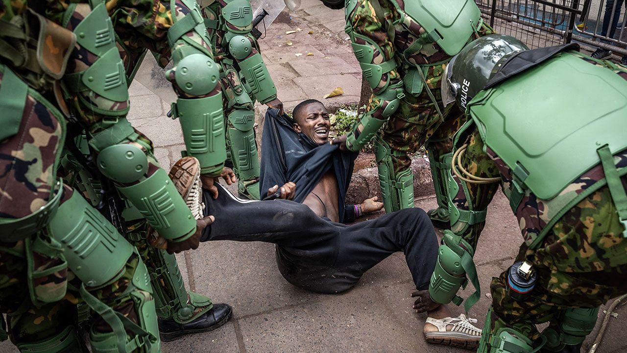 A man reacts on the floor as Kenya Police officers arrest him at a demonstration