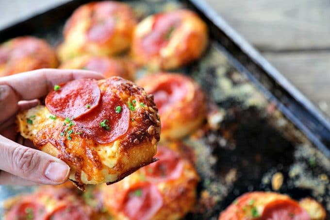 Pepperoni Pizza Bialys Recipe: fresh-from-the-oven, chewy, bagel-like bread topped with chopped garlic, the barest hint of pizza sauce and olive oil, a generous cap of melted cheese, and a couple of crispy-edged pepperoni to crown it.