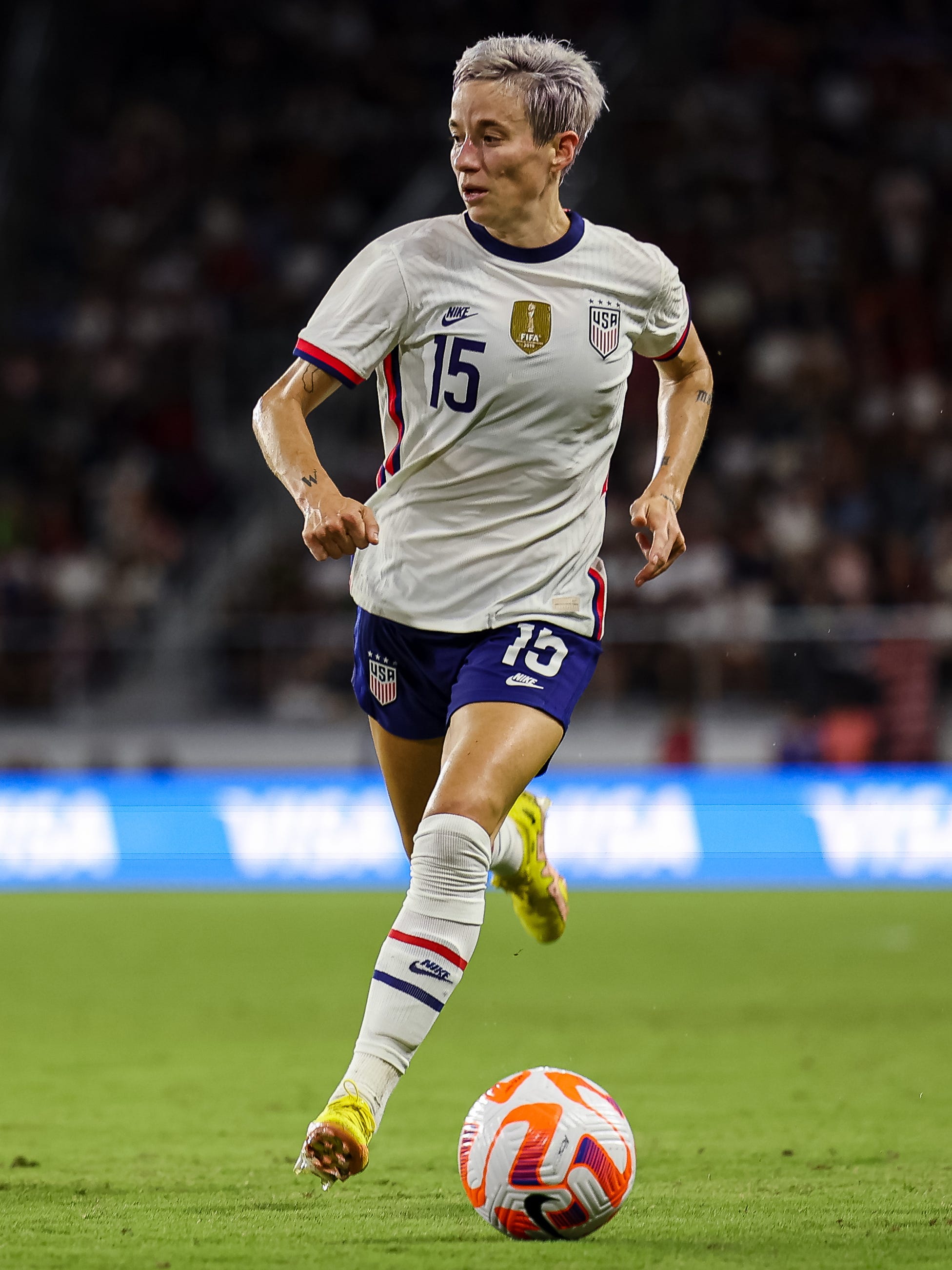 An action image of Megan Rapinoe playing soccer.