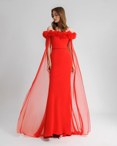 A draped flower embellishment off-the-shoulders, straight-cut red evening dress, with a flowy chiffon cape-like sleeves.