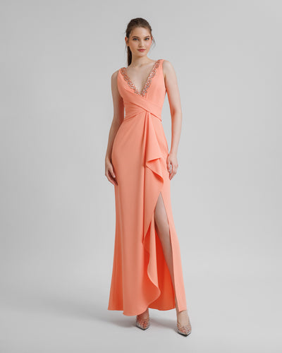 A peach beaded v-neckline evening dress featuring draping on the waist and a slit on the side.