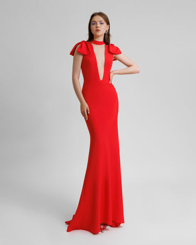 A deep V-neckline with slim-cut long red evening dress featuring bows on the shoulders and an open back.