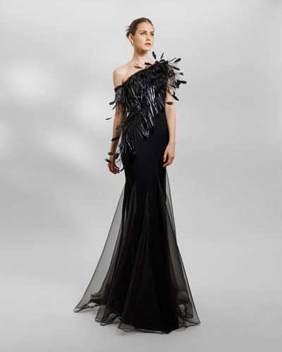 An asymmetrical feather neckline black evening dress with flared organza stripes.