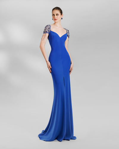 A sweetheart neckline slim-cut blue evening dress, featuring short full beaded see-through sleeves and a full open back with see-through tulle beadings and chains. This dress also has a high middle slit in the front.