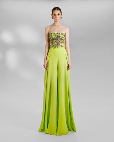 An evening wear set featuring a strapless beaded sheer corset top, with a flared pleated lime pants.