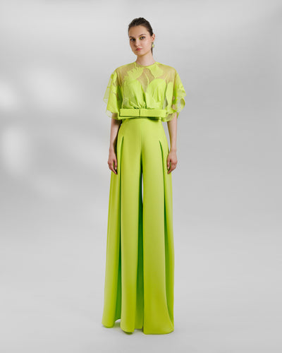An occasion wear featuring a patterned lace top with a bow design paired with a high-waist wide pants featuring side pleats, all in lime color.