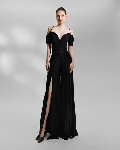 An evening wear black set featuring an off-the-shoulders, sweetheart beaded neckline top paired with wide pants with slits at the front.