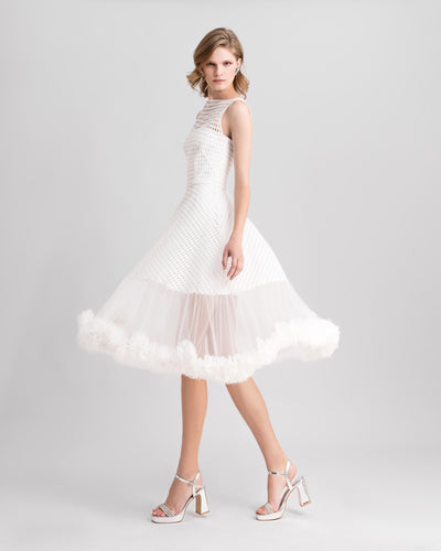 An ivory crochet lace flared midi dress with rushed tulle on the hemline.