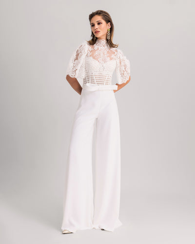 A white evening wear set featuring a high-collar lace top with flared sleeves paired with flared crepe pants.