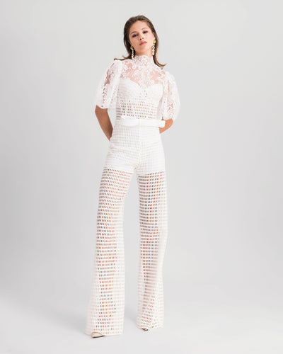 A white evening wear set featuring a high-collar lace top with flared sleeves and a bow design at the waist, paired with crochet lace straight-cut pants.