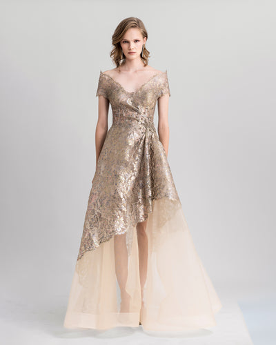 An off-the-shoulders golden evening dress featuring beadings on the waist and an asymmetrical crinoline skirt.