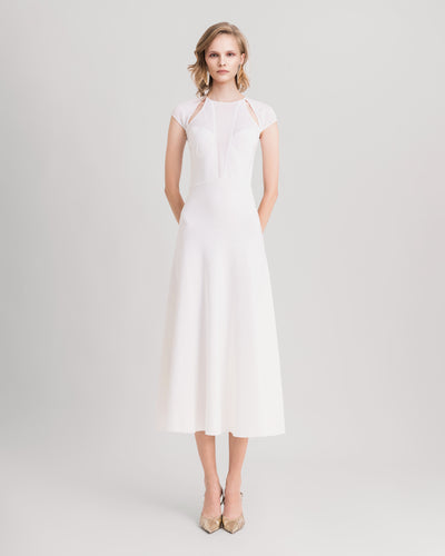 A white midi knit dress featuring cut-outs on the shoulders and a deep v-neckline.