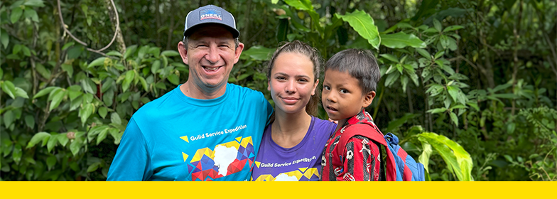 Guild Mortgage Volunteers with boy from local village