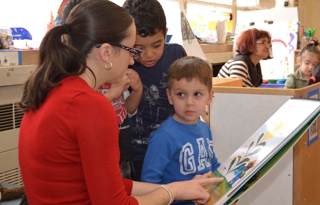 Teacher reading to a young boy.