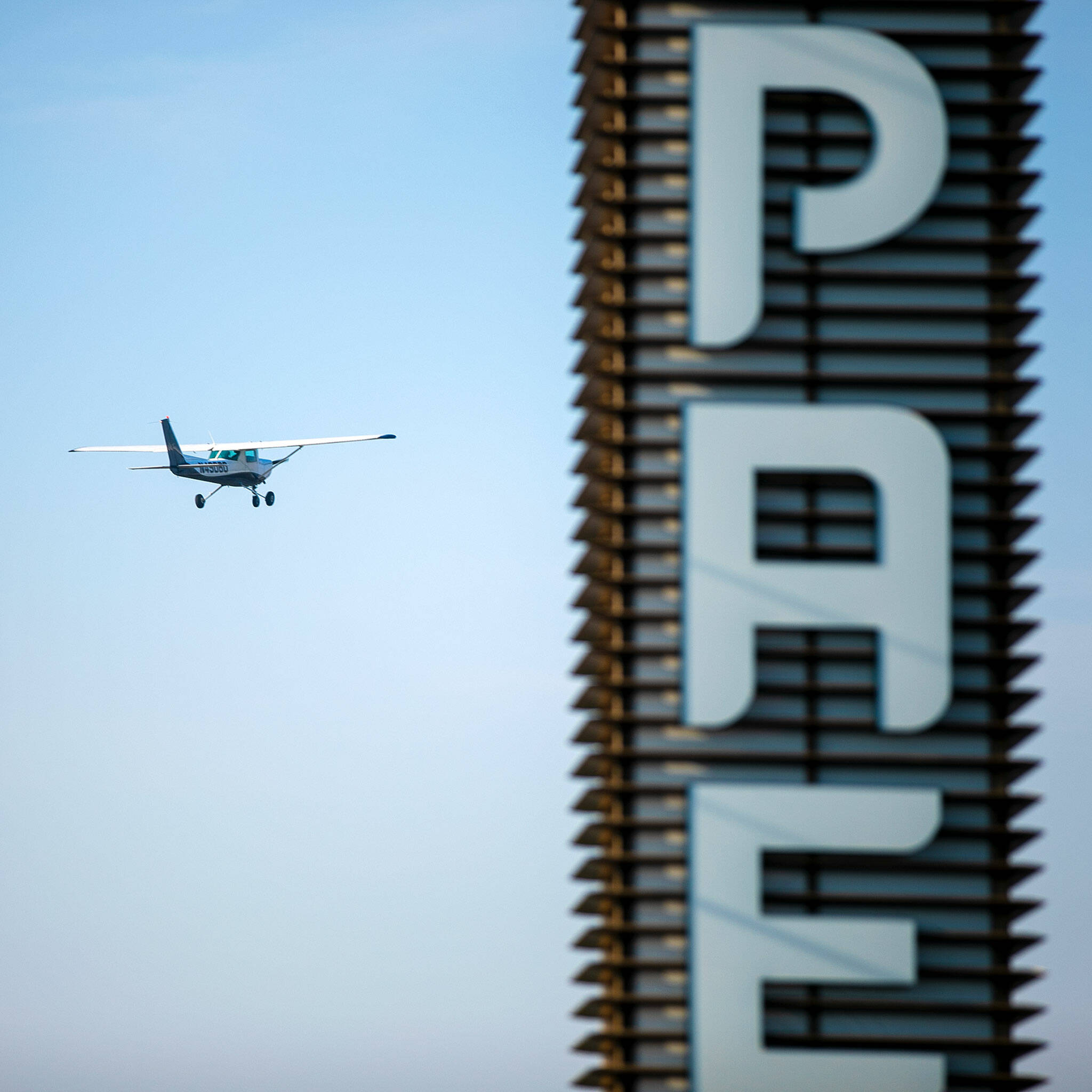 A 1979 Cessna 152 takes off from Paine Field and flies past the airport’s sign on Thursday, Oct. 13, 2022, in unincorporated Snohomish County, Washington. (Ryan Berry / The Herald)