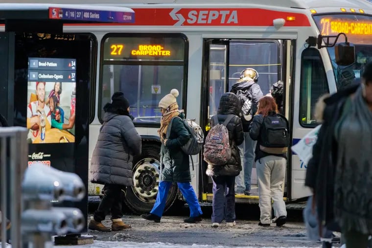 Commuters getting off and on the 27 SEPTA bus at 15th and Market Streets on a snowy morning in Center City Philadelphia on Tuesday, Jan. 16, 2024.