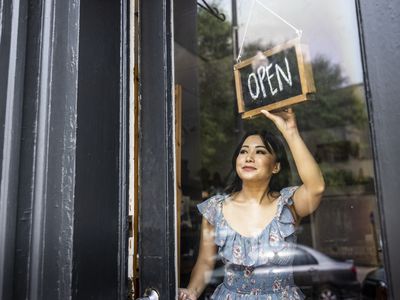 Small business owner turning open sign in her store