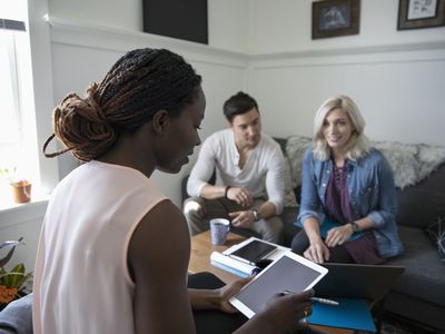 Financial advisor consulting with young couple in living room