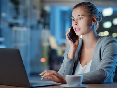 Woman sitting in front of a laptop making a call