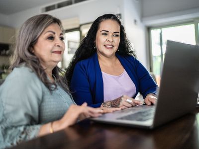 Two investors comparing markets on an open laptop