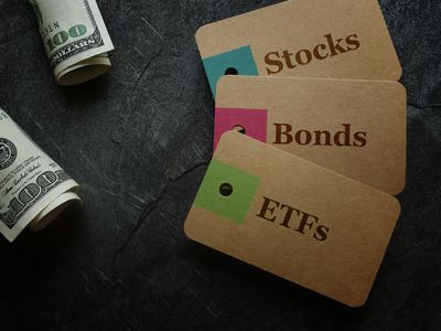 ETF (Exchange Traded Funds), Stocks and Bonds paper tags with cash on dark background.