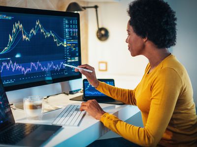 Woman checking stock market charts on a computer monitor