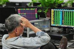 Investor looking with dismay at his positions on monitor