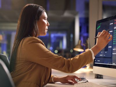 Woman looks at financial numbers on an office computer 