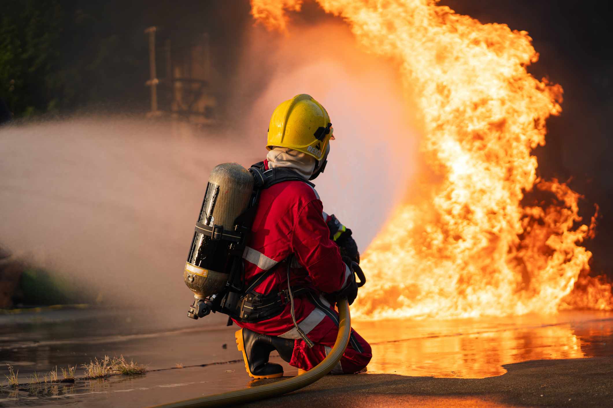 A firefighter tries to control a wildfire.