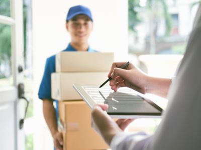 Someone signing for boxes delivered by a deliveryman