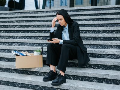 Woman looking at her phone to prepare filing a claim for wrongful termination