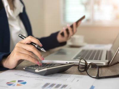 Close up of female accountant or banker making calculations. Savings, finances and economy concept